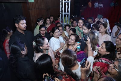 Anshu surrounded by guests after the show, phones raised around her.