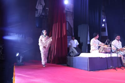Anshu walking on to the red-carpeted stage past the tabla player at the start of the evening.