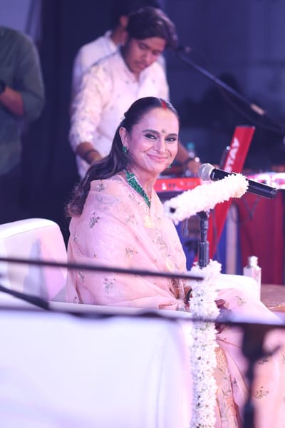 Anshu turning to the band with a grin between bhajans.