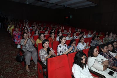 The audience applauding from the red seats, rows stretching back into the dark.